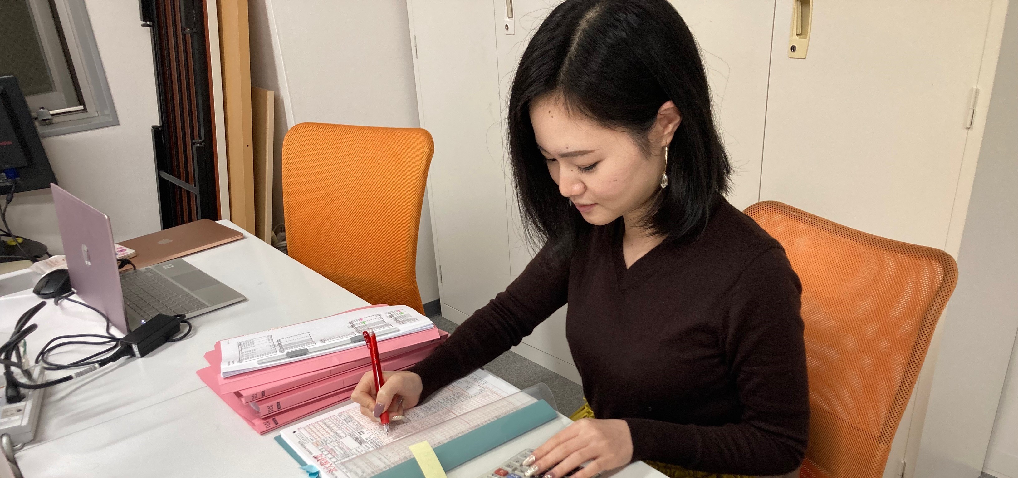 電卓を使い資料に書き込みをするスタッフ