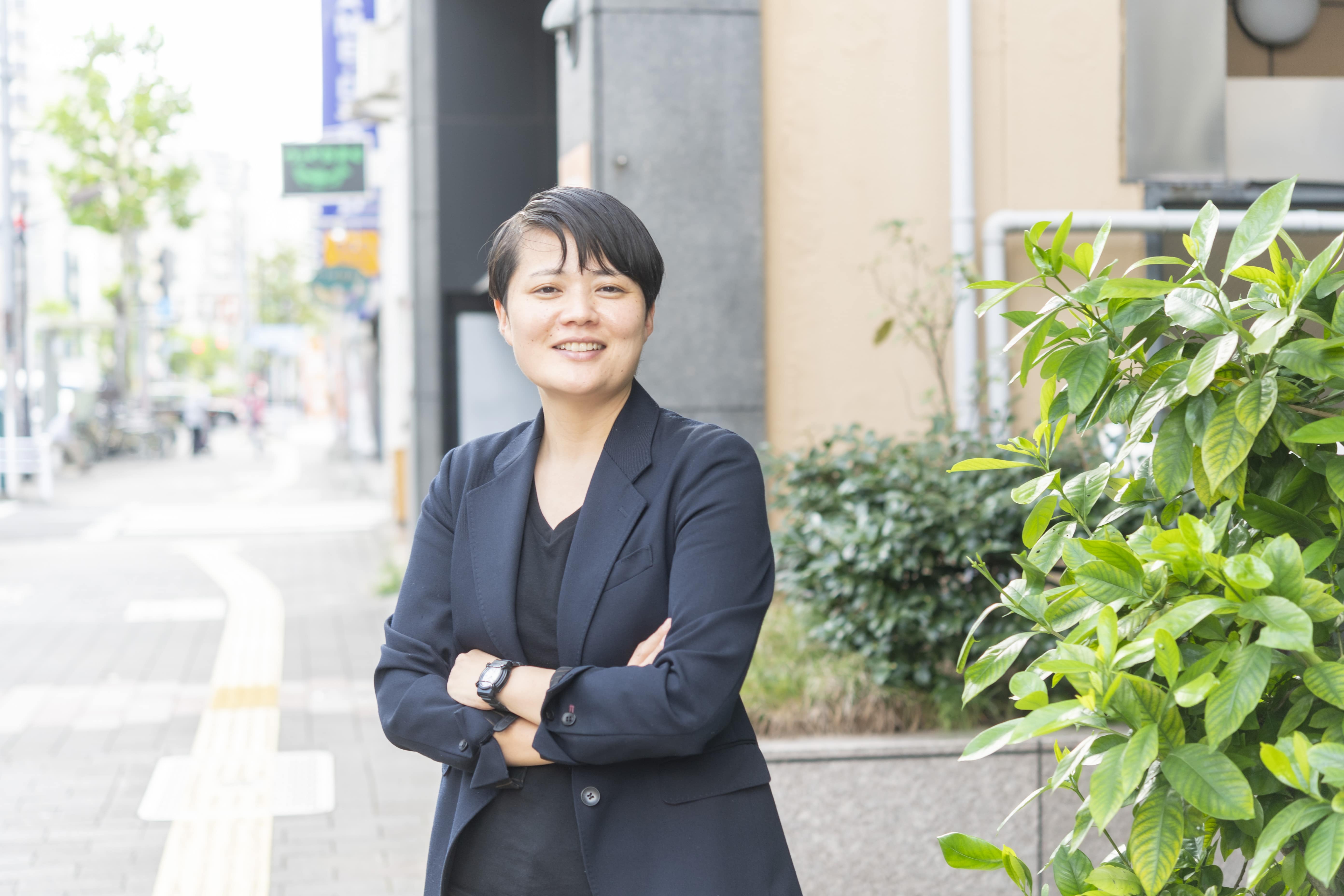 腕を組む佐藤抄(スタッフ)